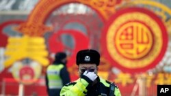 Un policía de tráfico se ajusta la mascarilla en una calle de Beijing, el domingo 9 de febrero de 2020. (AP Foto/Andy Wong)