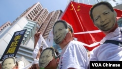 示威人士戴上李旺陽紙面具，在中聯辦門外模擬李旺陽站立自殺身亡不可信