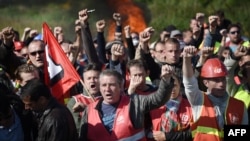 Des membres des syndicats français font grève près de la raffinerie de Total basée à Donges, à l'ouest de la France, pour protester contre la loi sur le travail le 27 mai 2016.