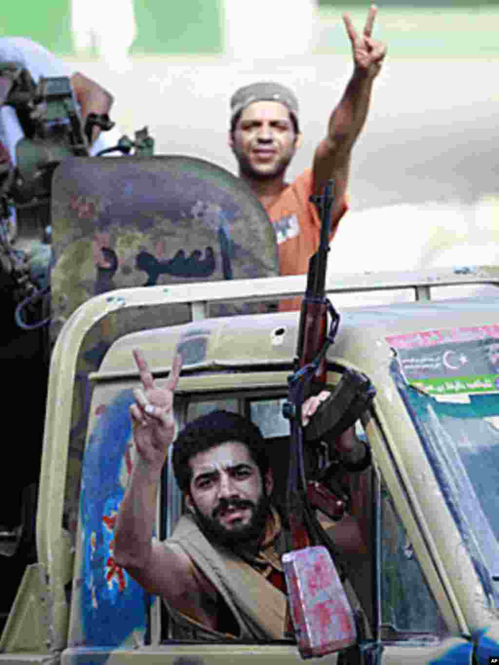 Libyan rebel fighters celebrate as they drive through Tripoli's Qarqarsh district, August 22, 2011. (Reuters)