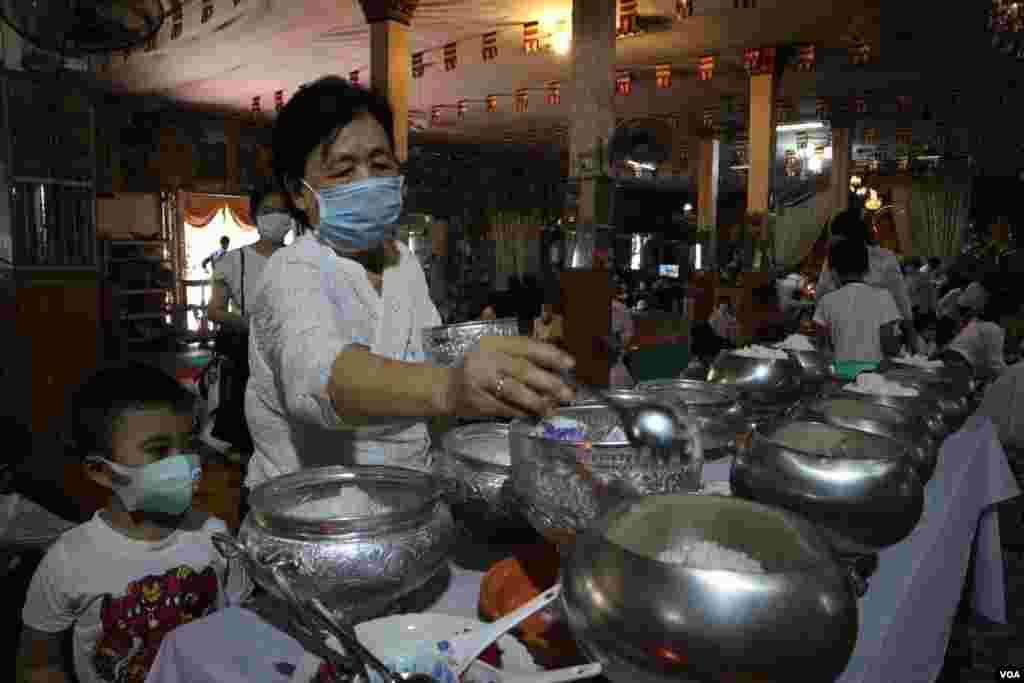 A Cambodian woman provides food offerings at Thann pagoda, Phnom Penh, Cambodia, Tuesday, April 14, 2020. (Kann Vicheika/VOA Khmer)