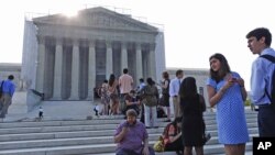 People line up in front of the Supreme Court in Washington, Jun. 24, 2013, before it opened for its last scheduled session. 