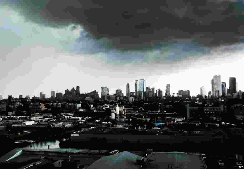 A part of Manhattan stands under a storm cloud as severe thunderstorms move across the region, in New York City. The city was under a severe weather threat for much of the evening.