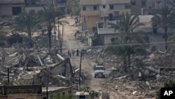 Egyptian army forces patrol amid the debris of houses destroyed by the army in the Egyptian border town of Rafah, as seen from the Palestinian side of Rafah in the southern Gaza Strip, Nov. 4, 2014. 