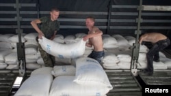 People lift up sacks which are part of a Russian convoy carrying humanitarian aid in Donetsk, eastern Ukraine. (File)