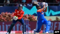 Rohit Sharma (R) of India hits 6 as Jos Buttler (L) of England looks on during the ICC men's Twenty20 World Cup 2024 semi-final cricket match between India and England at Providence Stadium in Georgetown, Guyana, on June 27, 2024. (Photo by Randy Brooks /