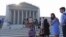 People line up in front of the Supreme Court in Washington, Jun. 24, 2013, before it opened for its last scheduled session. 