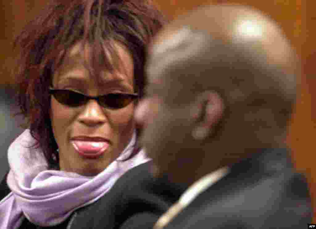 Singer-actress Whitney Houston, left, sticks her tongue out at her husband, singer Bobby Brown, during a court hearing on Monday, Nov. 25, 2002, in Dekalb County State Court in Decatur, Ga. Brown was arrested on an outstanding bench warrant for a DUI arre