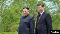 FILE - Chinese President Xi Jinping and North Korean leader Kim Jong Un walk during Xi's visit in Pyongyang, North Korea, in this picture released by North Korea's Korean Central News Agency on June 21, 2019.