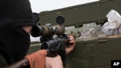 A Ukrainian serviceman guards positions in the village of Berdyanske near Shyrokyne, eastern Ukraine, April 14, 2015. 