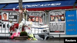 Flowers and messages in tribute to the victims of last year's January attacks are seen in front of the Hyper Cacher kosher supermarket at the Porte de Vincennes in Paris, France, Jan. 6, 2016. 