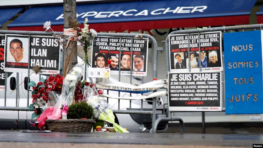 Karangan bunga dan pesan-pesan untuk mengenang para korban penembakan setahun yang lalu, terlihat di depan supermarket halal Hyper Cacher di Porte de Vincennes, Paris, Perancis (6/1). 