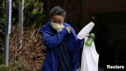 Seorang pekerja melepas masker setelah meninggalkan fasilitas perawatan Life Care Center of Kirkland yang terkait dengan beberapa kasus positif infeksi virus corona, di Kirkland, Washington, 6 Maret 2020.