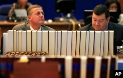 Shon Qualseth, left, lead counsel for the state and Kansas Solicitor General Steve McAllister, right, listen to appellate arguments during a hearing before the full, 14-member, Kansas Court of Appeals in Topeka, Kan., Dec. 9, 2015.