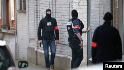 Police at the scene where shots were fired during a police search of a house in the suburb of Forest near Brussels, Belgium, March 15, 2016. 