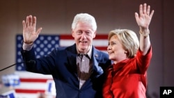 Kandidat capres Partai Demokrat Hillary Clinton, kanan, melambai dari panggung bersama suaminya mantan Presiden Bill Clinton di pemilihan pendahuluan kaukus Demokrat di Las Vegas, 20 Februari 2016. 