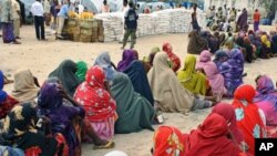 Internally displaced Somali women queue to receive food-aid rations at a distribution center in a displaced persons camp in the Somali capital Mogadishu, on July 26, 2011