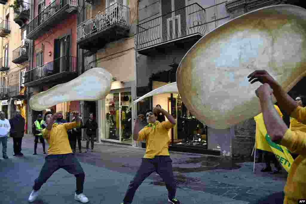 Members of the Pizzaioli Acrobats Coldiretti perform "twirling" pizza to celebrate the Unesco decision to make the art of Neapolitan "Pizzaiuolo" an "intangible heritage" in Naples.