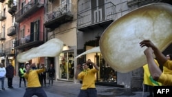 Members of the Pizzaioli Acrobats Coldiretti perform "twirling" pizza to celebrate the Unesco decision to make the art of Neapolitan "Pizzaiuolo" an "intangible heritage" in Naples.