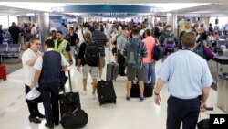 Los pasajeros caminan por el pasillo, el miércoles 31 de agosto de 2016, en el Aeropuerto Internacional de Fort Lauderdale-Hollywood en Fort Lauderdale, EEUU. 