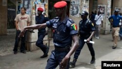 Un policier fait un geste à un partisan de l'opposition qui manifeste avant l'arrivée de Barack Obama, à Dakar, le 25 juin 2013.