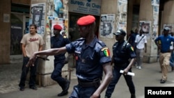 Un policier fait un geste au parti d'opposition qui manifeste avant l'arrivée de Barack Obama, à Dakar, le 25 juin 2013. 