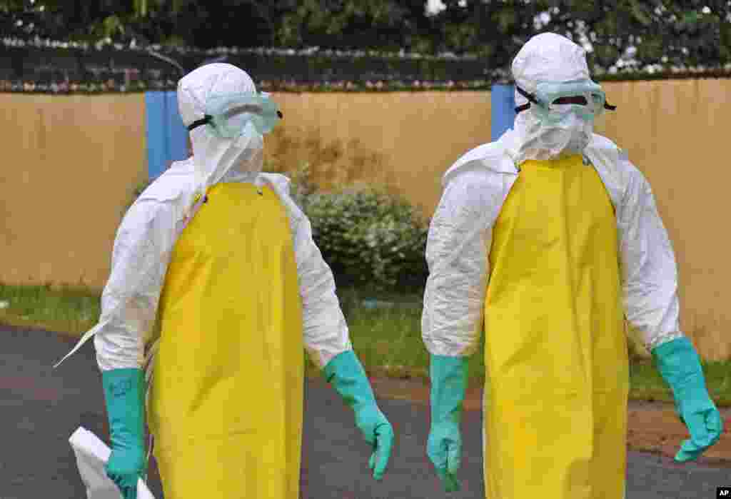 Les agents de santé portant un équipement de protection vont de retirer le corps d&#39;une personne qui est censée être décédée après avoir contracté le virus Ebola dans la ville de Monrovia, au Libéria, le 16 août 2014.
