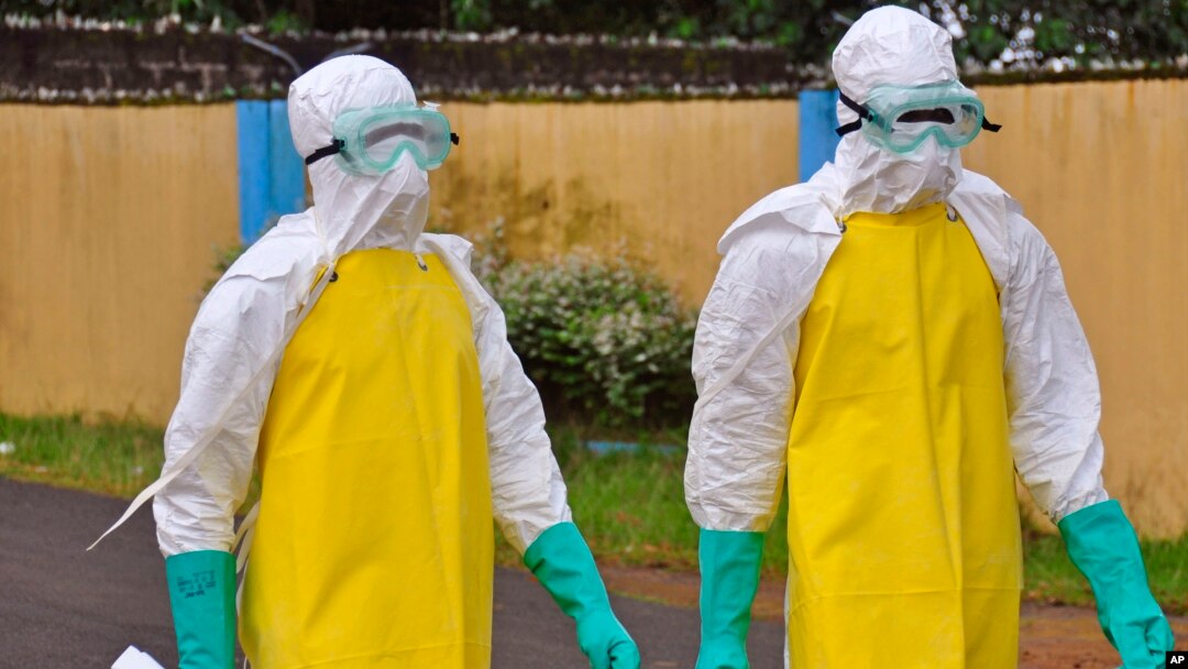Petugas kesehatan Liberia mengenakan pakaian pelindung untuk memindahkan jenazah bekas pasien ebola di Monrovia (16/8).