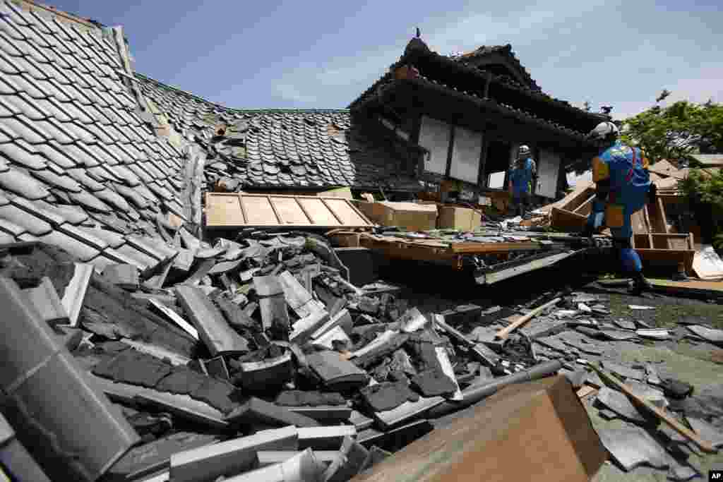 Rescue teams search through damaged houses to check for trapped people in Mashiki, Kumamoto prefecture, southern Japan. Aftershocks rattled communities in southern Japan as businesses and residents got a fuller look Friday at the widespread damage from an unusually strong overnight earthquake.