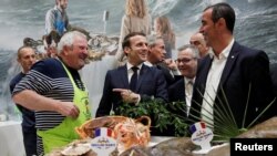 French President Emmanuel Macron visits the French fishing stand during the 57th International Agriculture Fair (Salon de l'Agriculture) at the Porte de Versailles exhibition center in Paris, France, Feb. 22, 2020.