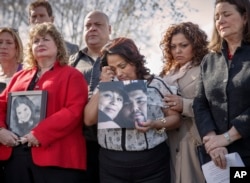 Rosie Cortinas (C) holds a photo of her son who was killed Oct. 18, 2013 while driving a Chevy Cobalt, joins other families whose loved ones died behind the wheel defective GM vehicles, during a news conference in Washington, April 1, 2014.