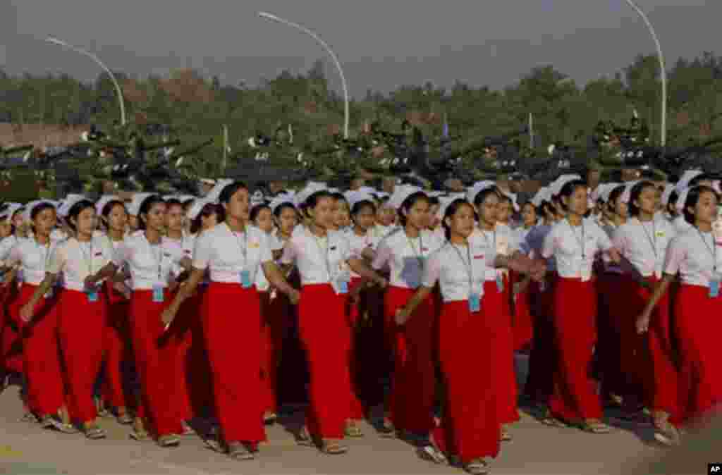 Myanmar nurses march in the foreground of army tanks during a ceremony to mark Myanmar's 67th anniversary of Independence Day in Naypyitaw, Myanmar, Sunday, Jan. 4, 2015. (AP Photo/Gemunu Amarasinghe)