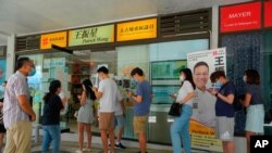 지난 12일 홍콩 범민주진영이 9월 입법회 의원 선거에 나설 후보를 선출하기 위해 실시한 예비선거 투표장에 유권자들이 줄지어 서 있다. 