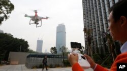 A staff member from DJI demonstrates the remote flying with his Phantom 2 Vision+ drone in Shenzhen, south China's Guangdong province, Monday, Dec.15, 2014. 