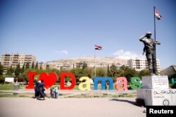 People stand at Umayyad Square in Damascus, Syria, April 7, 2017.