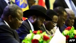 President of South Sudan, Salva Kiir signs a final power-sharing deal between South Sudanese arch-foes, Aug. 5, 2018, in Khartoum.