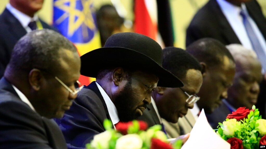 President of South Sudan, Salva Kiir signs a final power-sharing deal between South Sudanese arch-foes, Aug. 5, 2018, in Khartoum.