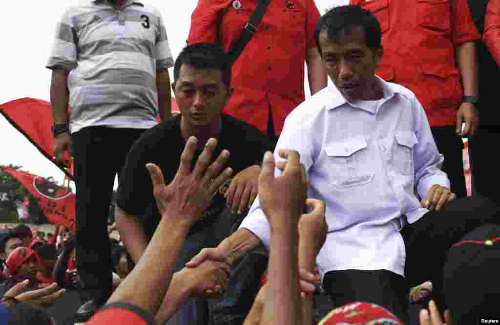 Jakarta governor and presidential candidate Joko Widodo greets his supporters during a PDI-P party campaign in Jakarta, March 16, 2014.&nbsp;