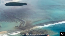This photo taken and provided by Eric Villars shows oil leaking from the MV Wakashio, a bulk carrier ship that recently ran aground off the southeast coast of Mauritius, Aug. 7, 2020.