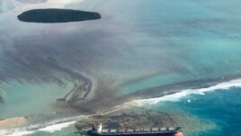 This photo taken and provided by Eric Villars shows oil leaking from the MV Wakashio, a bulk carrier ship that recently ran aground off the southeast coast of Mauritius, Aug. 7, 2020.