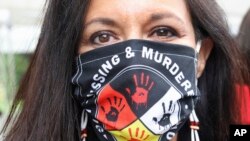 FILE - Jeannie Hovland, the deputy assistant secretary for Native American Affairs for the U.S. Department of Health and Human Services, poses with a Missing and Murdered Indigenous Women mask, Wednesday, Aug. 26, 2020, in Anchorage, Alaska.