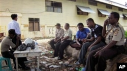 Polisi berjaga di luar stadion di Nabire, Papua, tempat lebih dari selusin orang tewas karena terinjak-injak menyusul kerusuhan dalam pertandingan tinju (15/7). (Foto: AP) 