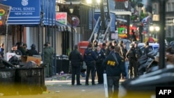 FBI investigators arrive at the scene where the white Ford F-150 pickup truck that crashed into a work lift after allegedly driving into a crowd of New Year's revelers in the French Quarter of New Orleans, Louisiana, on January 1, 2025.