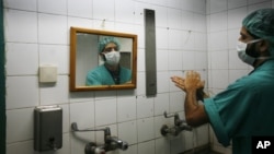 FILE - A Palestinian doctor washes his hands prior to performing a surgery at Shifa hospital in Gaza City, Jan. 27, 2009. Health officials see hand-washing as the single most important measure for preventing surgical site infections.