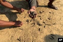 FILE - A local resident holds up bullet casings in a village in Rathedaung township, Rakhine state, after fighting between the Myanmar military and the Arakan Army, an ethnic Rakhine force, Jan. 28, 2019.