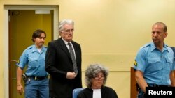 FILE - Bosnian Serb wartime leader Radovan Karadzic appears in the courtroom for his appeals judgement at the International Criminal Tribunal for Former Yugoslavia at The Hague.