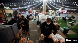 Seorang penjual menyiapkan hamburger di Radical Barbecue, sebuah kios makanan, di Al Aali Mall di Manama, Bahrain, di tengah pandemi COVID-19, 27 Februari 2021. (REUTERS/Hamad I Mohammed)