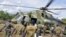 Ugandan soldiers, who are tracking down Lord's Resistance Army (LRA) fugitive leaders, load supplies off a military helicopter in a forest bordering Central African Republic, South Sudan and Democratic Republic of Congo, near river Chinko, April 18, 2012.