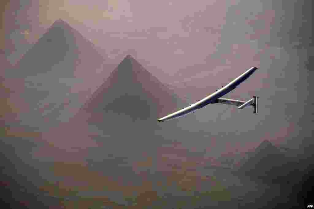 This handout photo released by Solar Impulse 2 shows the solar powered plane, piloted by Swiss pioneer André Borschberg, during the flyover of the pyramids of Giza prior to landing in Cairo, Egypt.