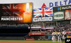 New York Yankees outfielders Aaron Hicks (31), Jacoby Ellsbury,(22) and Aaron Judge (99), lower right, stand at attention as the British National Anthem is played prior to a baseball game against the Kansas City Royals at Yankee Stadium in New York, in memory of victims of the Manchester, England bombing, May 23, 2017.